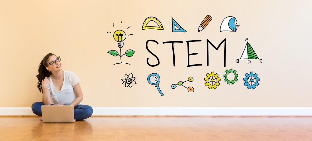 Best STEM Careers for women. woman sitting on floor looking at STEM written in the air. 